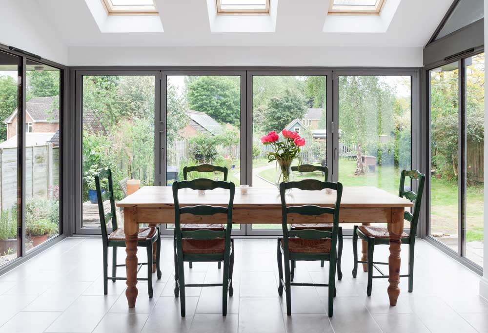 interior image of a dining table surrounded by bifold doors leading to the garden