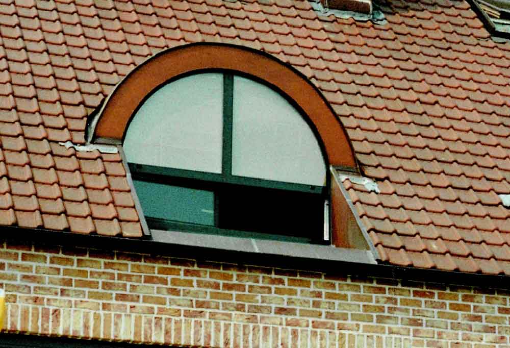small arched window on the roof of a residential property