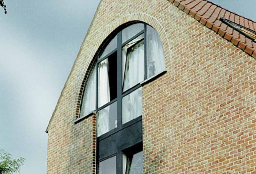 arched aluminium windows on the side of a residential property using a tilt mechanic