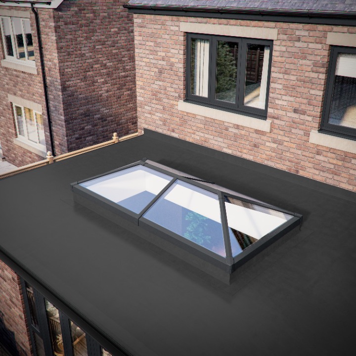 An exterior bird's-eye view of a flat roof extension attached to a red brick house, featuring a rectangular Iconiq lantern roof with a dark grey frame.
